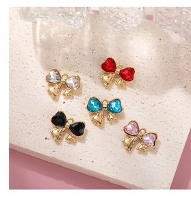 Flat lay of colorful bow-shaped heart pendants with glass crystals for DIY jewelry making