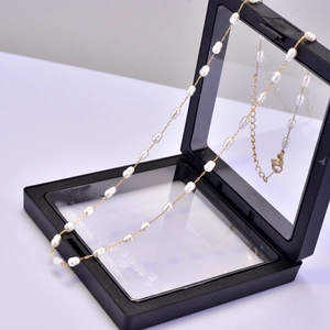 Close-up of baroque pearl necklace with 18K gold chain in black PE display gift box