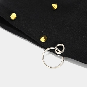 Detail of black knit beanie featuring gold cone studs and silver metal rings decoration