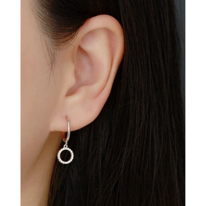 Macro shot of a minimalist s925 silver hoop earring with sparkling zircon on earlobe