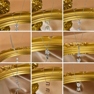 Collection of nine stainless steel necklaces with diverse pendants on vintage mirror base