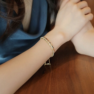 Dettaglio del bracciale geometrico a doppia fila di strass indossato al polso femminile
