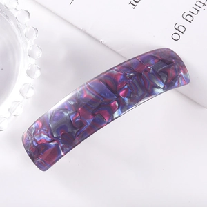 Detail shot of rectangular hair clip with purple and blue marbled acetate pattern