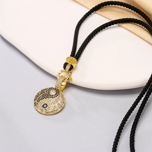 Dettaglio macro del ciondolo Tai Chi con placcatura in oro e cristalli neri e bianchi