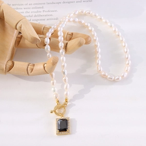 Lustrous natural pearl necklace with black zircon pendant and golden OT clasp on hand