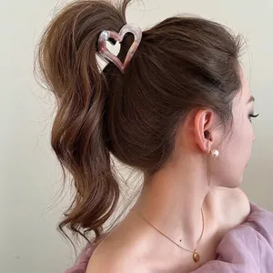 Pink marble heart hair claw clip for high ponytail styling on brunette hair