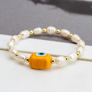 Freshwater pearl bracelet with yellow evil eye pendant and golden spacer beads for women