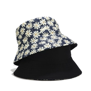 Reversible floral bucket hat with navy daisy print and minimalist black side for sun protection