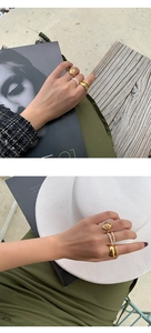 Detail of stacked gold-toned metal rings and handmade freshwater pearl beaded rings set