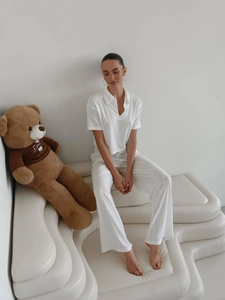 Close-up of white knit hollow texture on V-neck polo top and wide-leg pants set