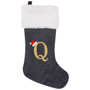 Detailed view of gray velvet Christmas stocking with golden glitter letter Q embroidery