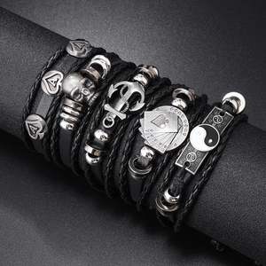 Punk multilayer leather bracelet set with skull, anchor and poker charms on a display stand