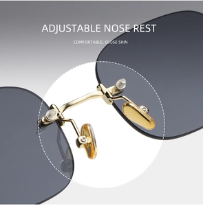 Detail of adjustable gold nose pads and dark grey lenses on rimless sunglasses
