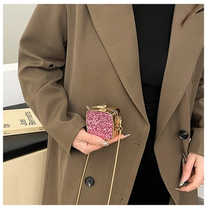 Close-up of pink glitter acrylic mini evening bag with gold chain and metal clasp