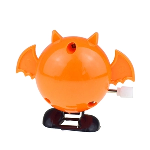 Macro view of orange wind-up bat toy with black wings and white clockwork knob