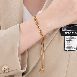18K gold-plated adjustable checkered strap chain bracelet with heart charms on a model