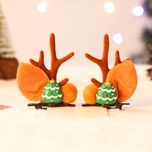 Detailed view of reindeer antler hair clips with miniature Christmas trees on faux snow