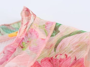 Detailed macro shot of floral print poplin fabric and fine stitching on a pink shirt