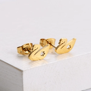 Elegant gold-plated swan stud earrings with hollow flower detail on a white pedestal