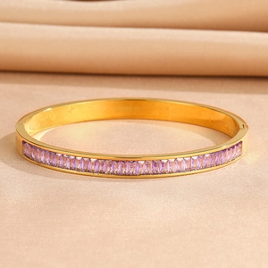 Macro detail of gold-plated stainless steel bangle with purple rectangular zircon stones