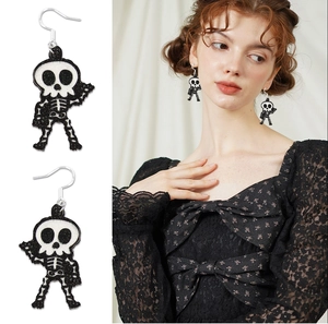 Glittery black and white skull earrings for Halloween party outfits on model
