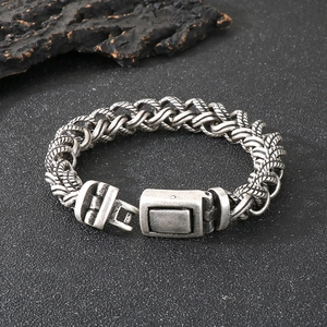 Macro detail of men's vintage oxidized silver stainless steel woven chain bracelet