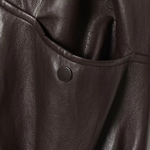 Deep brown biker leather vest with textured grain and metallic snap button pocket details