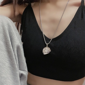 Close-up of model wearing titanium steel necklace with Venus relief face pendant