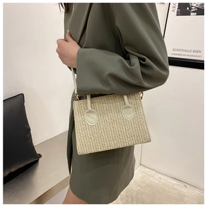 Fashionable beige woven crossbody bag worn by a model in a minimalist modern setting