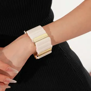 Chic cream white and gold geometric wave bracelet worn by a model in a side view