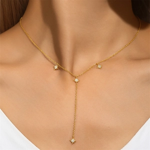 Macro detail of a 925 sterling silver Y-shaped tassel necklace with gold star pendants