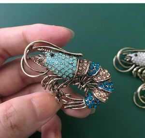 Detailed view of a vintage lobster brooch with champagne and blue rhinestones on bronze