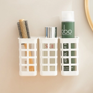 Wall-mounted white mesh storage baskets for curling irons and bathroom accessories
