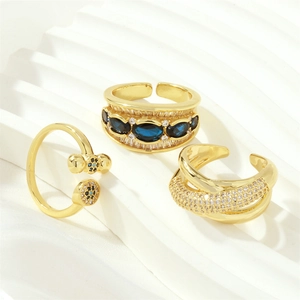 Detailed view of three gold-plated rings with blue oval gemstone and micro zircons