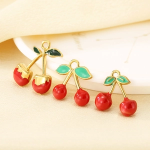 Three assorted red cherry fruit pendants in stainless steel with gold metal accents