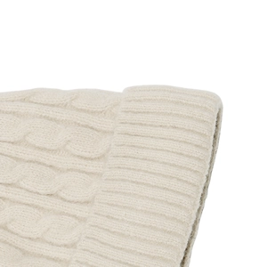 Détail macro du bonnet en maille torsadée beige chaud montrant la texture de la laine