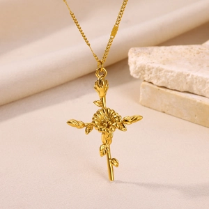 Detailed close-up of a gold-plated necklace featuring a floral cross pendant design