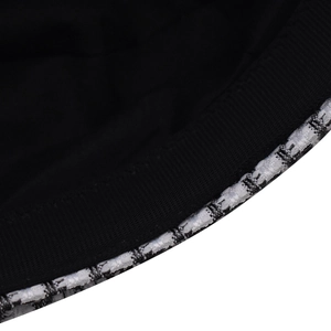 Close-up of houndstooth tweed fabric texture and black sweatband on the beret hat