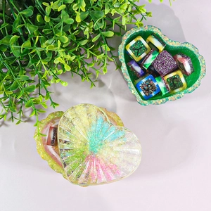 Macro shot of striped heart resin box set with green glitter finish and alphabet beads