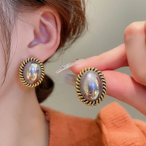 Détail d'une boucle d'oreille ovale vintage avec perle violette et bord doré