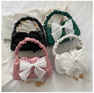 Fashionable PU leather handbags in four colors featuring large bow accents and gold chains
