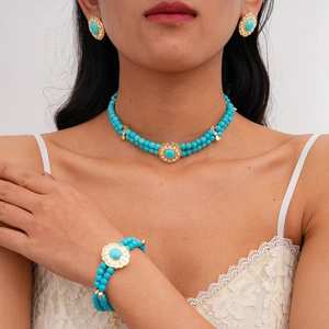 Detail shot of bohemian gold necklace and bracelet set with turquoise beads and sun flowers