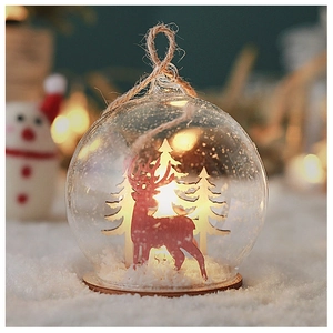 Detail of Christmas glass ornament with reindeer and pine tree on a wooden base
