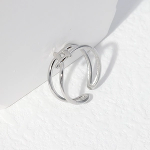 Detail of silver adjustable ring featuring a brushed texture and H-shaped central link