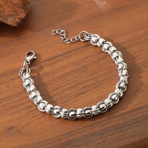 Detail of silver link chain bracelet with lobster clasp and extender on wood surface