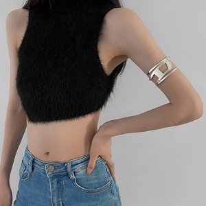 Macro detail of silver polished metal arm cuff featuring a hollow D-shaped cutout design