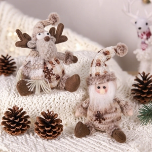 Knitted Christmas gnome and reindeer plush figurines on a cozy blanket with pinecones