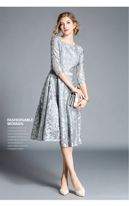 Detail of grey lace embroidery fabric texture on a slim fit dress with white leather belt