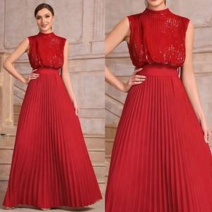 Detail of red sleeveless sequined evening gown featuring a pleated skirt and high neck