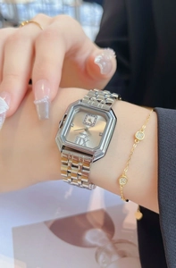 Gros plan d'une montre carrée vintage avec cadran champagne et bracelet en maille dorée